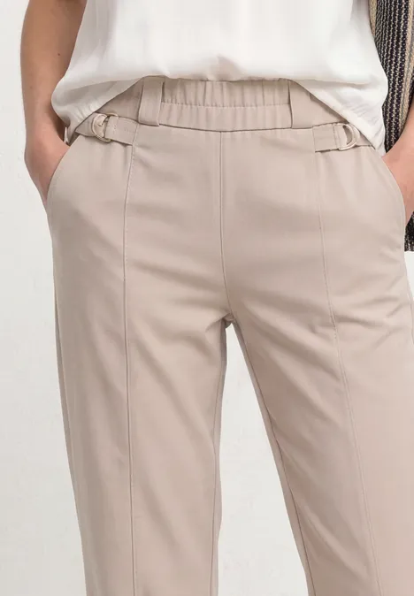 Helle, beige Hose mit elastischem Bund und Eingrifftaschen, getragen von Modell.