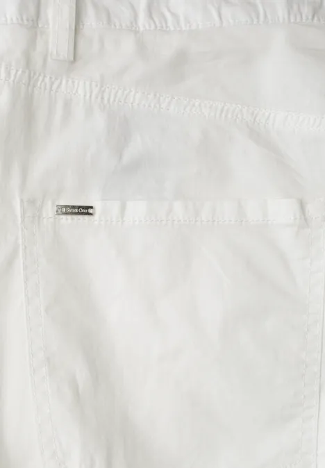 Nahaufnahme einer weißen Hosentasche mit Metall-Label