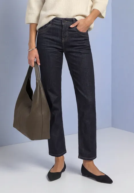 Mid Waist Straight Leg Jeans im Casual Fit Rinse Washed Dunkelblaue, gerade geschnittene Jeans, schwarze Ballerinas und eine olivgrüne Handtasche.