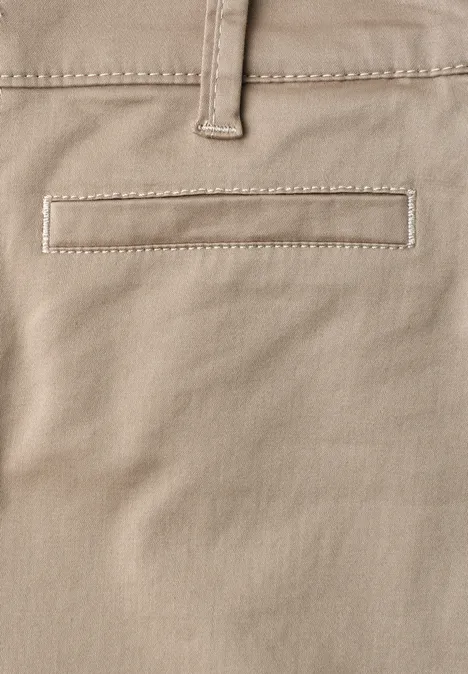 Gros plan sur un pantalon beige clair avec une poche arrière passepoilée et une boucle de ceinture.