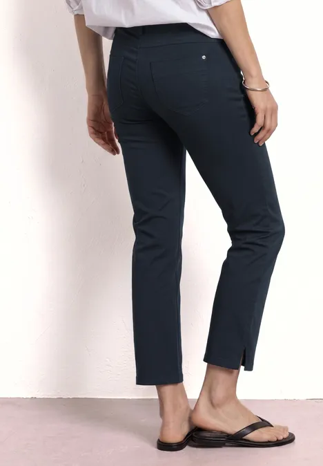 3/4 broek met flared pijpen in casual pasvorm shadowed navy Vrouw draagt marineblauwe, enkellange, recht gesneden broek en zwarte sandalen.