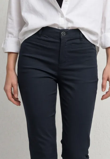 3/4 broek met flared pijpen in casual pasvorm shadowed navy Een persoon draagt een wit overhemd en een donkere, getailleerde chinobroek.