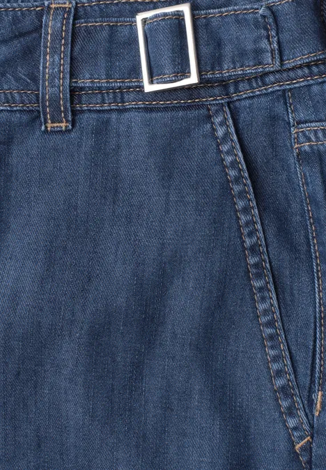 Detailansicht einer blauen Jeanshose mit Gürtelschlaufe, Metallverschluss und Nahtverlauf.