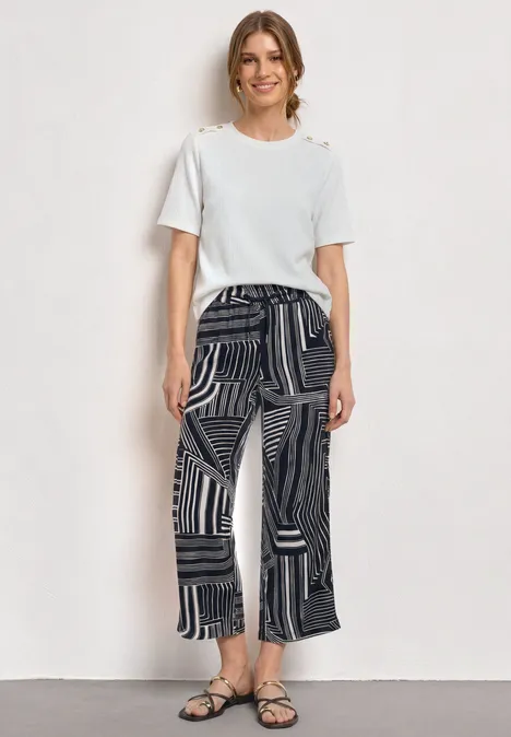 High Waist Culotte mit Muster darkest blue Frau in weißem T-Shirt und gemusterten, weit geschnittenen Hosen mit Sandalen