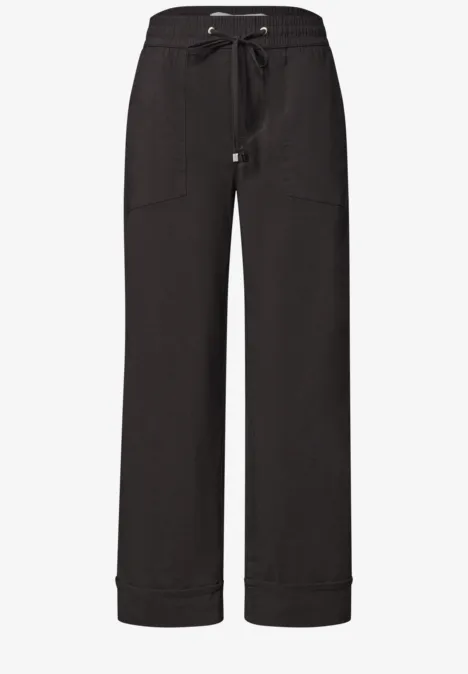 Schwarze, weite Hose mit Tunnelzugbund und aufgesetzten Taschen.