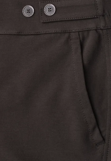 Nahansicht einer dunkelbraunen Hose: Hosentasche und Taillenbund mit zwei Knöpfen.