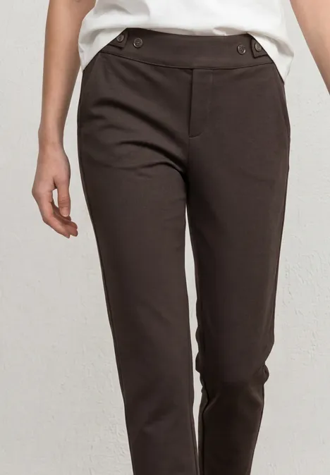 Braune Damenhose mit schmalem Schnitt, hoher Taille und seitlichen Knopfdetails.