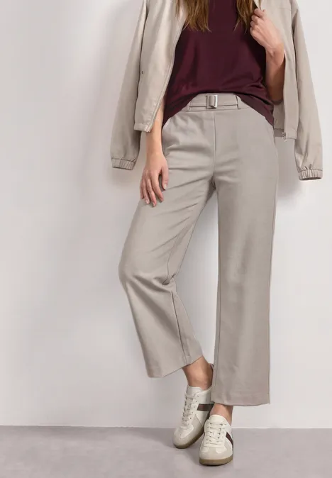 High Waist Culotte met gespdetails clay sand Persoon draagt beige wijde broek, bordeauxrode top, beige blazer en witte sneakers voor witte achtergrond.