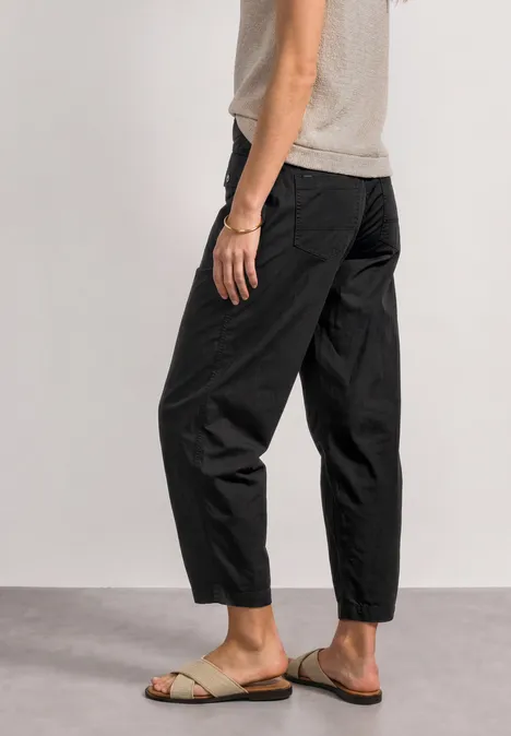 Schlichte schwarze Hose und helle Sandalen, lässig geschnitten