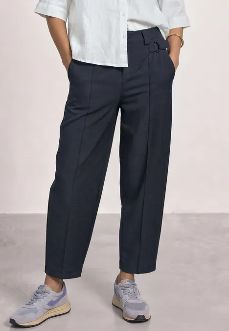 High Waist Barrel Leg Hose im Casual Fit darkest blue Person trägt dunkelblaue, hochgeschnittene Anzughose mit Bundfalte und graue Sneaker.