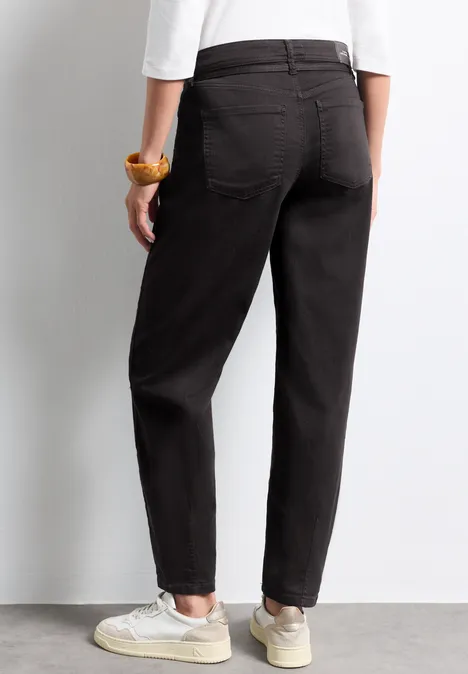High Waist Barrel Leg Jeans im Loose Fit Brown Washed Rückansicht einer Person in schwarzen Hosen und weißen Sneakern.