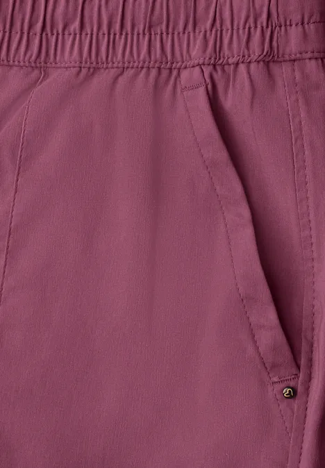 Nahaufnahme einer himbeerfarbenen Hose mit elastischem Bund und schräger Seitentasche.