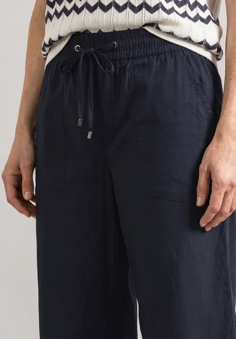 Pantalon Straight Leg et décontracté, avec revers darkest blue Pantalon ample bleu foncé à taille élastiquée et cordon, associé à un top imprimé.