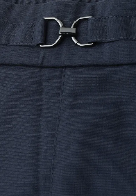 Detailaufnahme eines dunkelblauen Stoffes mit silbernem Schnallenverschluss