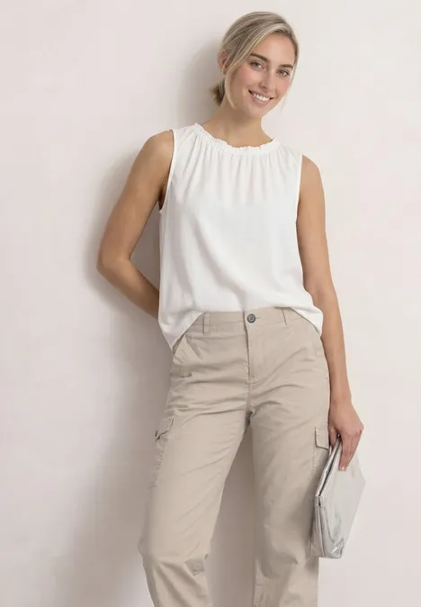 Straight Leg Hose im Cargo-Look clay sand Junge Frau in beige Hose und weißem ärmellosen Oberteil, hält eine hellgraue Clutch.