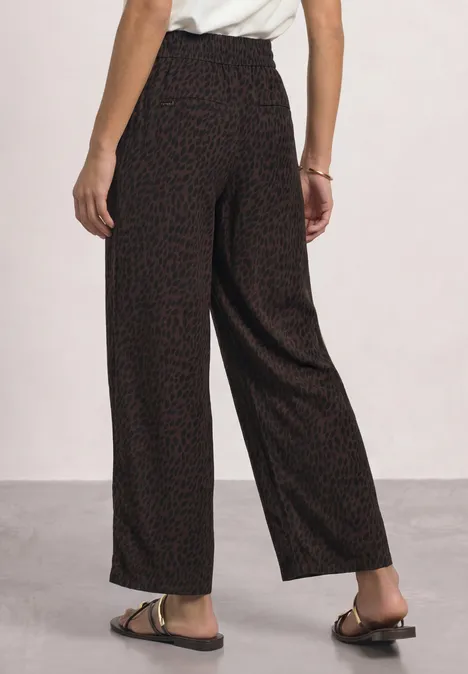 Mid Waist Straight Leg Hose mit Print molten earth Schwarz-rote, weite Damenhose mit Feinstrukturmuster, hoher Bund, locker fallend, kombiniert mit flachen Sandalen.