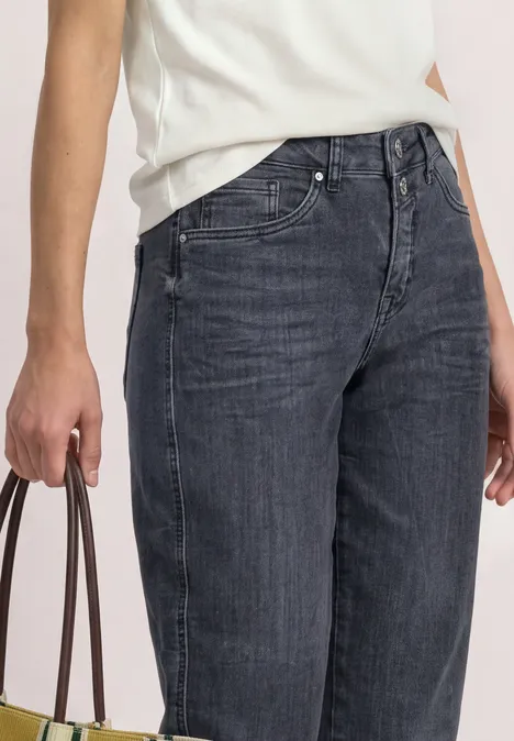 High Waist Barrel Leg Jeans im Loose Fit Steel Grey Washed Eine Person trägt dunkle High-Waist-Jeans und hält eine braune Handtasche, weißes Oberteil teilweise sichtbar.