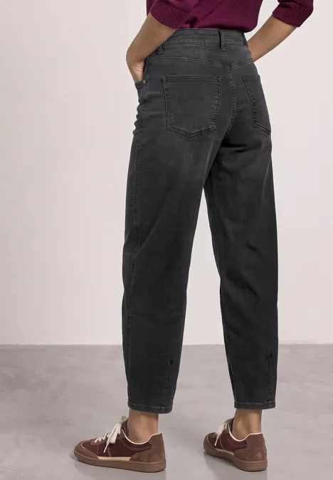 High Waist Barrel Leg Jeans im Loose Fit Black Washed Rückenansicht einer Person in hoch taillierter, lockerer schwarzer Jeans und braunen Schuhen.