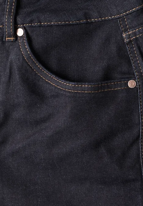 Nahaufnahme einer dunkelblauen Jeans mit Fronttasche, kontrastierenden Ziernähten und Metallnieten.