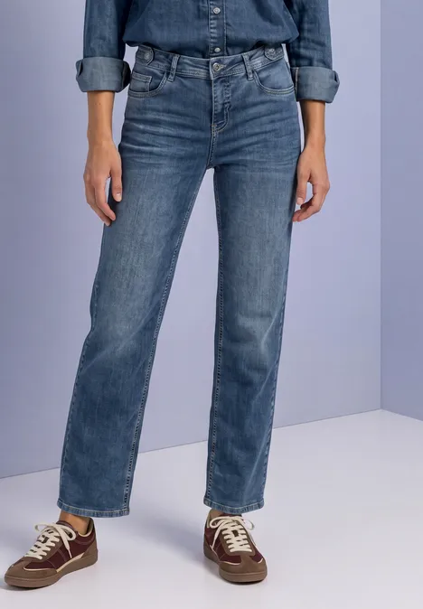 Jeans z prostymi nogawkami i guzikowymi detalami Medium Blue Random Washed Osoba na jasnym tle w niebieskich dżinsach i brązowych trampkach.