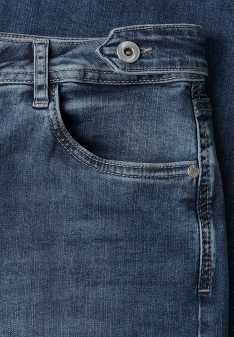 Jeans z prostymi nogawkami i guzikowymi detalami Medium Blue Random Washed Zbliżenie niebieskich dżinsów z kieszenią, szlufkami i widocznym guzikiem.