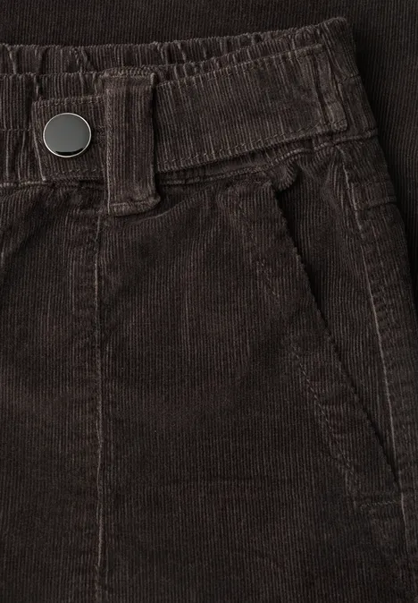 Nahaufnahme einer braunen Cordhose mit elastischem Bund, Gürtelschlaufen und seitlicher Einschubtasche.