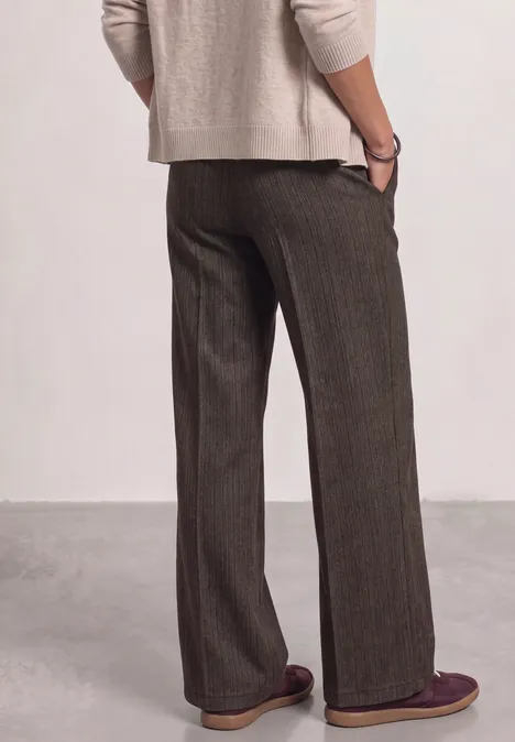 Pantalon taille haute Straight Leg avec détail boutonné black coffee Personne de dos portant un pull beige et un pantalon ample marron