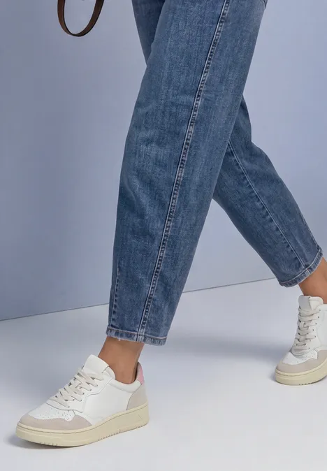 Jean taille haute à Barrel Leg, coupe ample Medium Blue Soft Washed Sneakers blanches et jeans bleus décontractés sur un fond clair