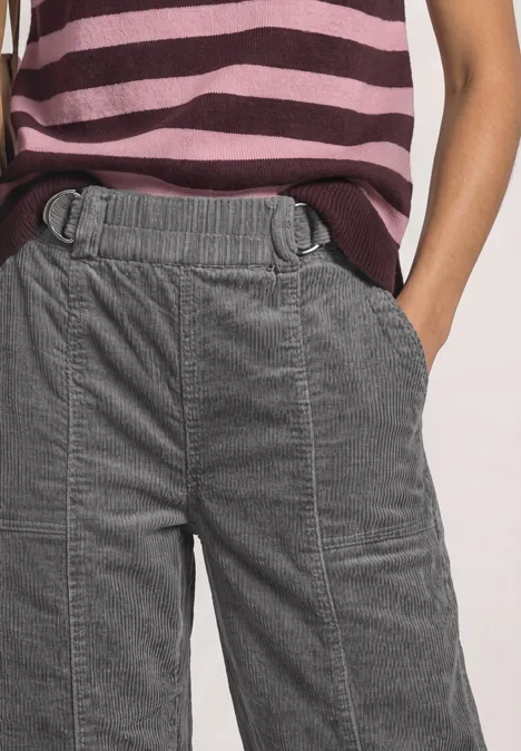 High Waist Barrel Leg Hose mit Elastikbund eclipse grey Frau trägt graue Cordhosen mit elastischem Bund und tiefen Taschen, kombiniert mit gestreiftem Shirt.