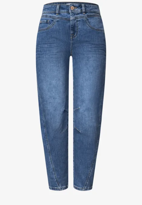 Ein Paar blaue Jeans mit hoher Taille, schmal zulaufenden Beinen und leichter Rissoptik.