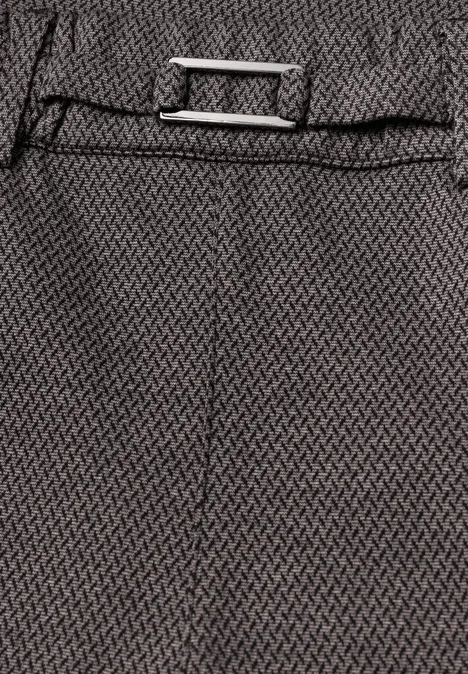 Gros plan d’un tissu gris à motif zébré, couture centrale et boucle rectangulaire argentée.