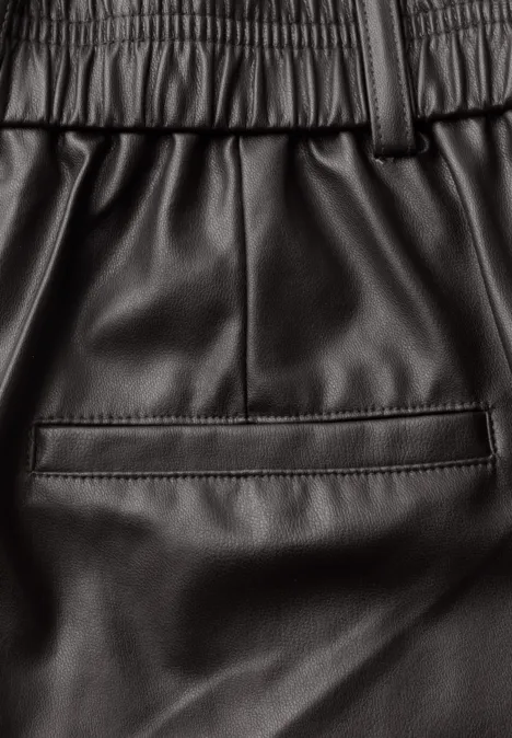 Schwarze Kunstlederhose mit elastischem Bund und Leistentasche am Rücken.