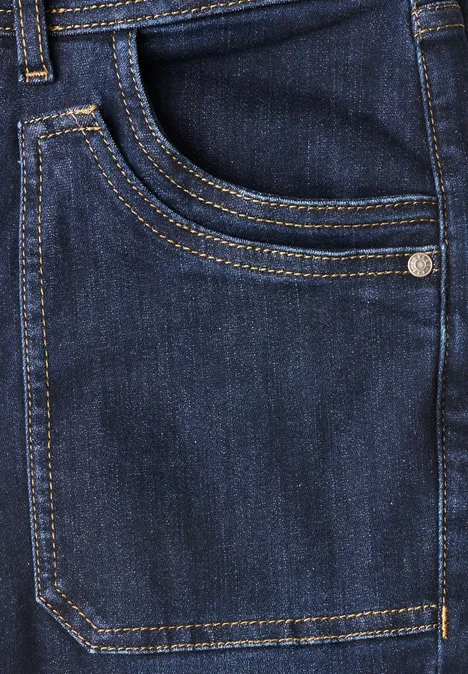 Nahaufnahme einer blauen Jeans mit sichtbarer Tasche und gelben Ziernähten
