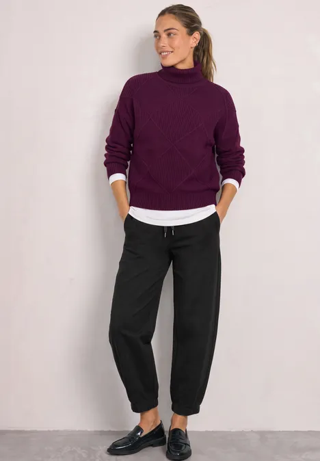 Pantalon taille haute Barrel Leg, coupe décontractée Black Frau in lila Rollkragenpullover, weißem Hemd und schwarzen, lockeren Hosen mit schwarzen Schuhen.