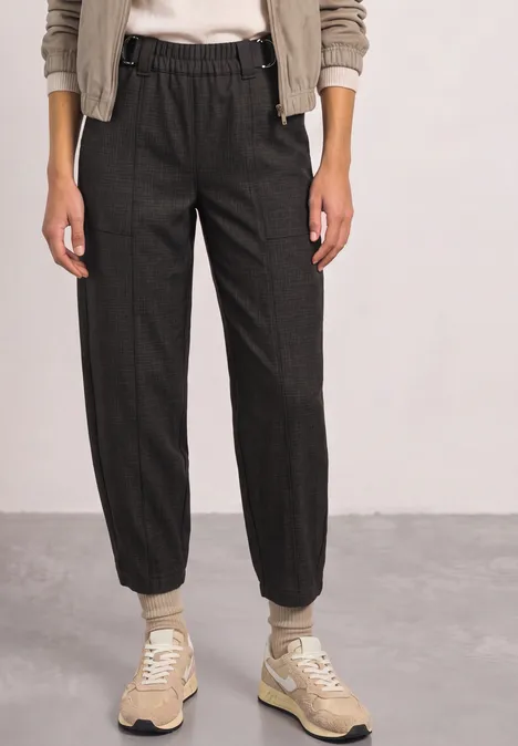 High Waist Barrel Leg Hose im Casual Fit black coffee Eine Person trägt dunkelgraue, locker sitzende Jogginghose mit Gummizug und beigen Sneakern.