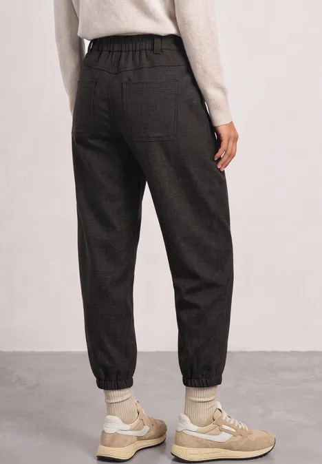 High Waist Barrel Leg Hose im Casual Fit black coffee Schwarze Jogginghose mit elastischem Bund und Bündchen, getragen mit beigen Sneakers.