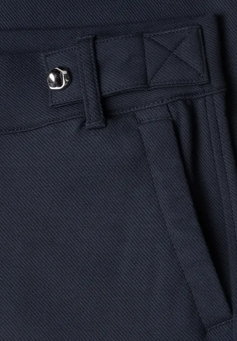 Close-up van een donkerblauwe stoffen broek met riemlus en zijzak.