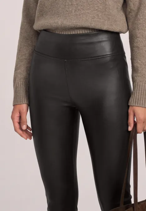 Leggings in Leder-Optik black coffee Schwarze, hochgeschnittene Lederleggings kombiniert mit grob gestricktem Pullover und Handtasche.