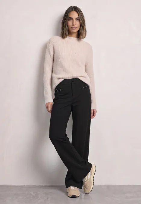 Broek met Mid Waist-taille en Straight Leg-pijpen in casual pasvorm Black Eine Frau in hellbeigem Pullover, weiten schwarzen Hosen und Sneakern steht vor hellgrauem Hintergrund.