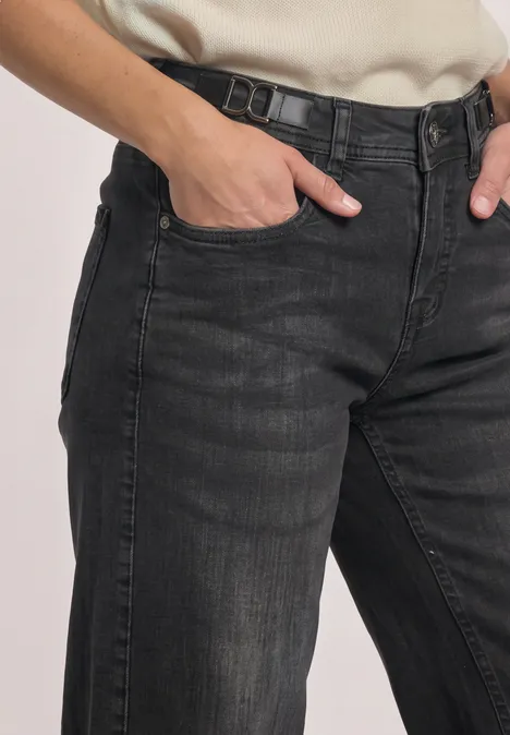 Mid Waist Wide Leg Jeans im Loose Fit Black Washed Schwarzgraue Jeans mit Hand in der Hosentasche, klare Nähte und dezentes Used-Finish.