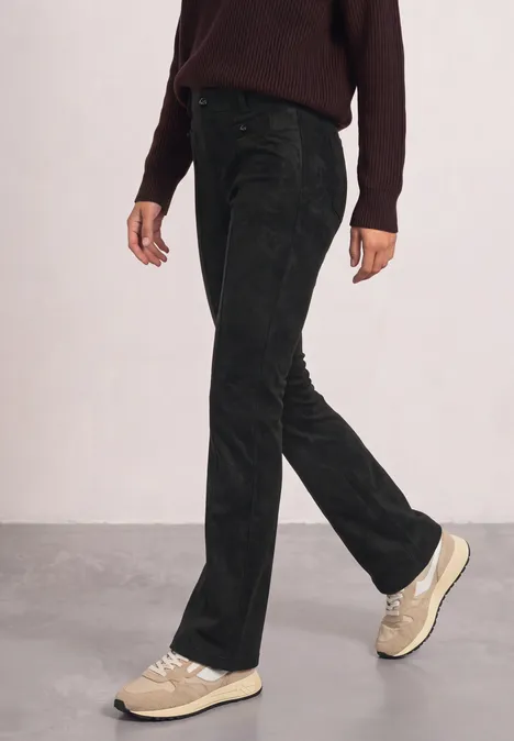High Waist Bootcut Hose im Slim Fit Black Seitliche Ansicht einer Person in schwarzen Hosen und hellen Sneakern beim Gehen.