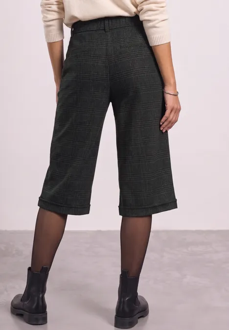 Bermuda met High Waist en Wide Leg pijpen in casual pasvorm Black Rückansicht einer Person in weiten, midilangen grünen Culottes, schwarzen Strumpfhosen und schwarzen Boots.