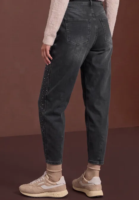 High Waist Barrel Leg Jeans im Loose Fit grey washed Dunkelgraue, locker sitzende Jeans mit Perlenbesatz an den Seiten, umgeschlagene Säume und cremefarbene Sneaker.