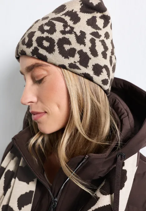 Femme de profil portant un bonnet et une veste assortis façon léopard beige et marron