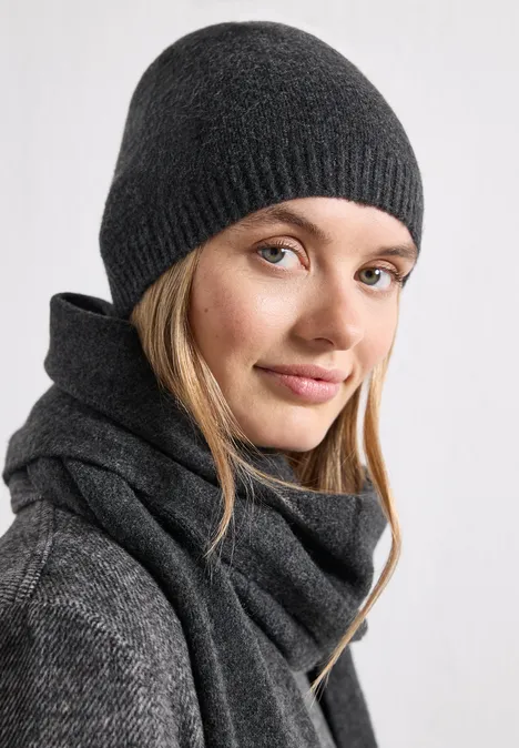 Feinstrick Beanie in Unifarbe anthracite melange Frau in grauer Strickmütze und Schal blickt lächelnd in die Kamera.
