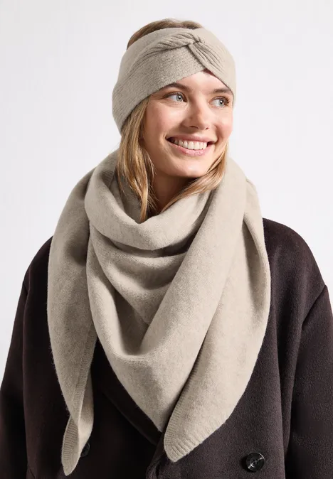 Feinstrick Dreieckstuch in Unifarbe Soft Sand Mel. Frau mit beigem Strickstirnband und passendem Schal, dunklem Mantel, lächelnd