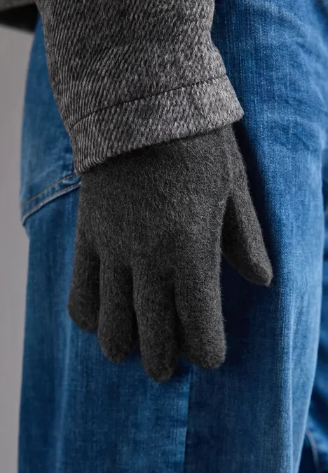 Feinstrick Handschuhe in Unifarbe anthracite melange Eine Hand mit grauem Wollhandschuh neben blauer Jeanshose