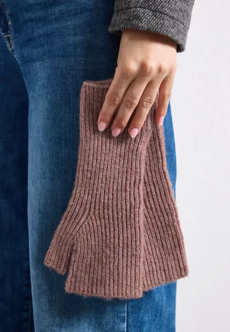 Person hält ein Paar fingerlose, gerippte Handschuhe aus braunem Strick