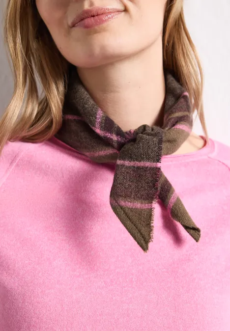 Close-up van persoon met roze trui en vooraan geknoopte, groen-bruine gestreepte sjaal.