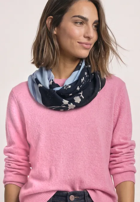 Loop-Schal mit floralem Muster indigo night Frau trägt rosafarbenen Pullover und marineblaue Schlaufe mit weißem Blumenmuster.